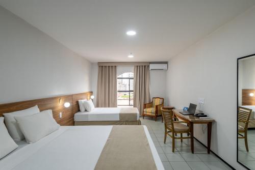 a hotel room with a bed and a desk at Hotel Resort Rio Poty in São Luís