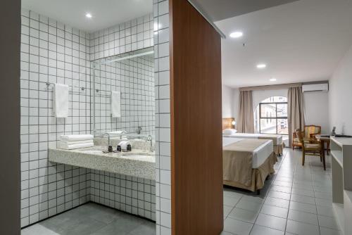 a hotel room with a bed and a bathroom at Hotel Resort Rio Poty in São Luís