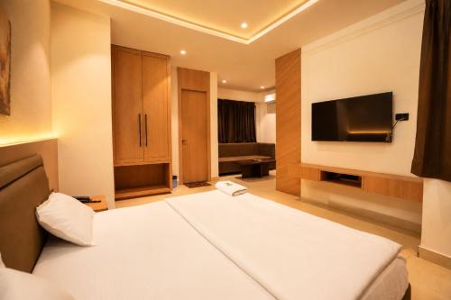 a hotel room with a bed and a flat screen tv at Hotel River Front in Kota