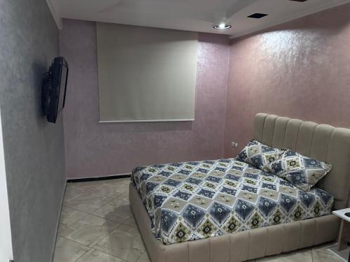a bedroom with a bed and a projection screen at Appartement in Khouribga