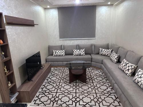 a living room with a couch and a table at Appartement in Khouribga