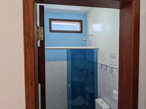 a bathroom with a shower with a glass door at Pousada Manacá — Beachfront Guesthouse on Ilha Grande in Abraão