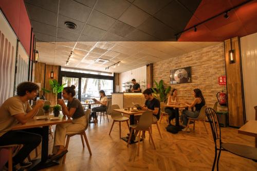 a group of people sitting at tables in a restaurant at U-nit Hostel Central Park in Valencia