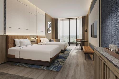 a hotel room with two beds and a television at Four Points by Sheraton Guilin Central in Guilin