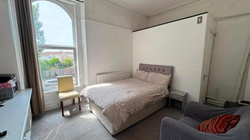 a small bedroom with a bed and a window at Singleton Double Studio Room with Private En-Suite in Sketty