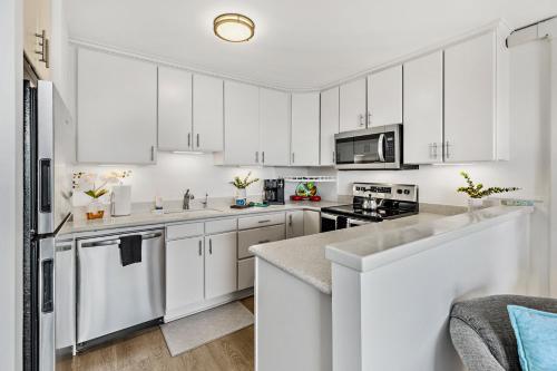 a white kitchen with white cabinets and appliances at OB - Lahaina Roads 308 in Lahaina