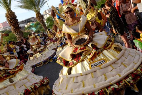 a group of women in elaborate costumes in a parade at Casa Comba in Mindelo