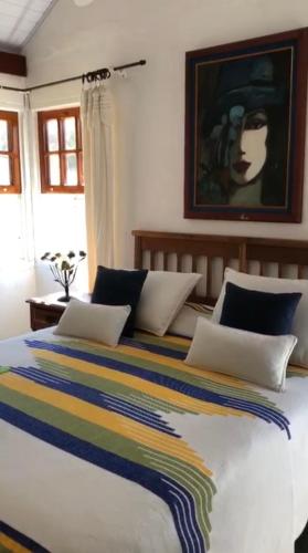 a bedroom with a large bed with a colorful blanket at Pousada Vidinha Bela in Brazópolis