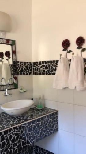 a bathroom with a white sink and a mirror at Pousada Vidinha Bela in Brazópolis