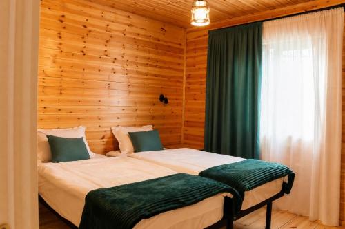 a bedroom with two beds and a window at Cottage Deera in Mestia