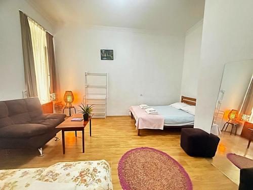 a living room with a bed and a couch at Legacy Rooms in Old Tbilisi FREE parking in Tbilisi City