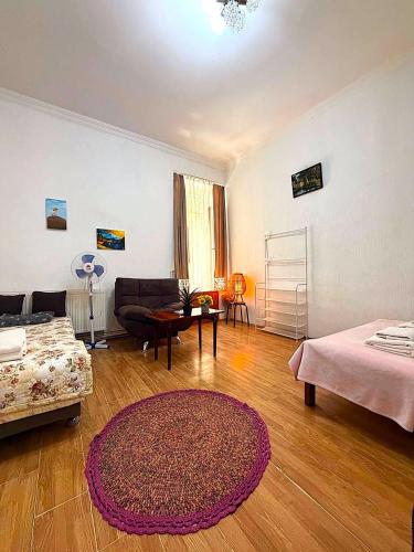 a living room with a couch and a rug at Legacy Rooms in Old Tbilisi FREE parking in Tbilisi City