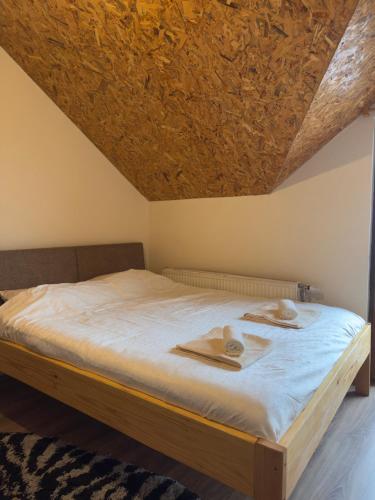 a bed in a bedroom with a wooden ceiling at Villa Harmonia in Ferizaj