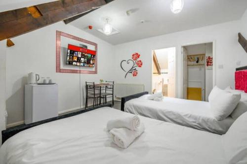 two beds in a room with white walls at RB1GH- Cosy Room SECURE PARKING NEAR CITY CENTRE FAST WIFI in Bramley