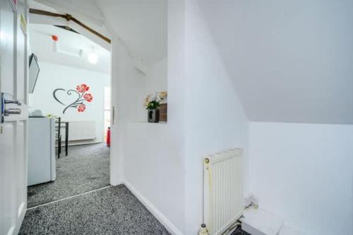 a hallway with a white wall with flowers on it at RB1GH- Cosy Room SECURE PARKING NEAR CITY CENTRE FAST WIFI in Bramley