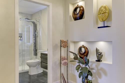 a bathroom with a shower and a toilet and a sink at Unwind centrally in West Kelowna