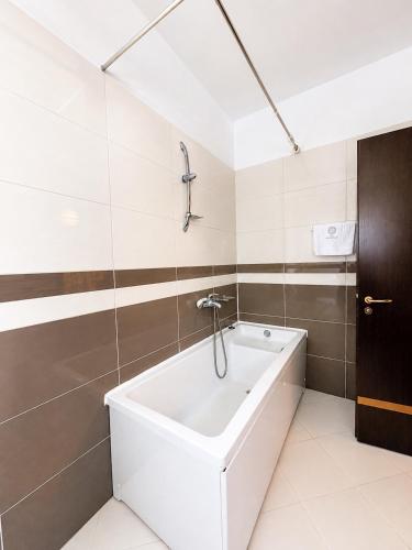 a bathroom with a bath tub and a sink at Hotel President in Shëngjin