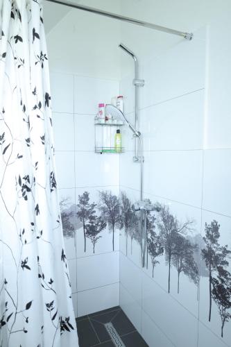 a shower curtain in a bathroom with trees on the wall at Villa Harmonia in Ferizaj