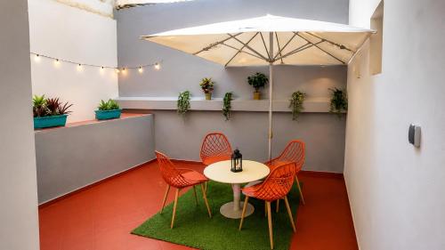 a table with chairs and an umbrella in a room at chic appart vue sur piscine in Tangier