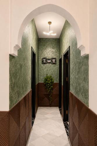 an archway leading to a hallway with green walls at chic appart vue sur piscine in Tangier