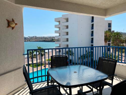 a balcony with a table and chairs and the ocean at Hermoso condominio frente al mar in San Carlos