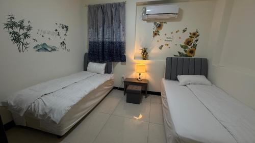 a room with two beds and a lamp in it at 潔希民宿一館 in Hsin-chieh