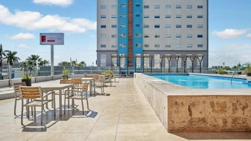 a hotel patio with tables and chairs next to a pool at Fiesta Inn Ciudad Juarez in Ciudad Juárez