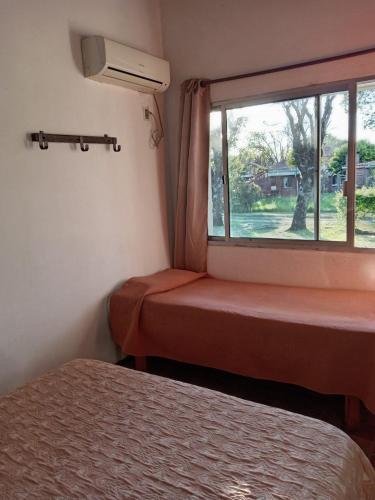 a room with a window with a bed and a window seat at Brisas Del Rio Apart Hotel in Termas del Daymán