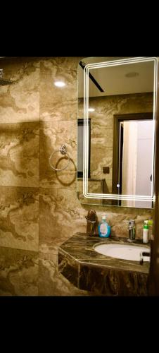 a bathroom with a sink and a mirror at White420 apartment in Rawalpindi