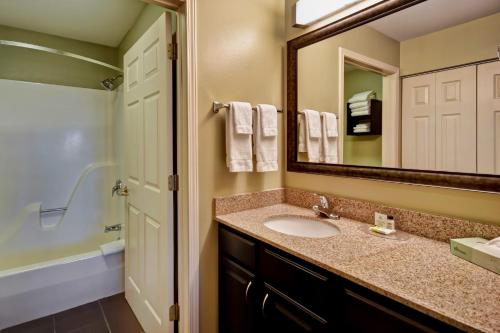 a bathroom with a sink and a mirror at Staybridge Suites Madison - East by IHG in Madison
