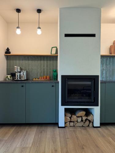 a kitchen with a fireplace in the middle at Garden 52 in Šutovce