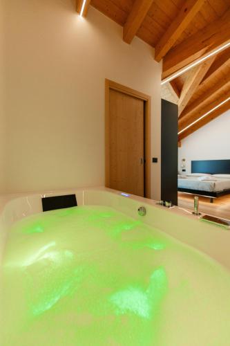 a bath tub filled with green water in a room at Hotel Villa Amabile in Villa dʼAllegno