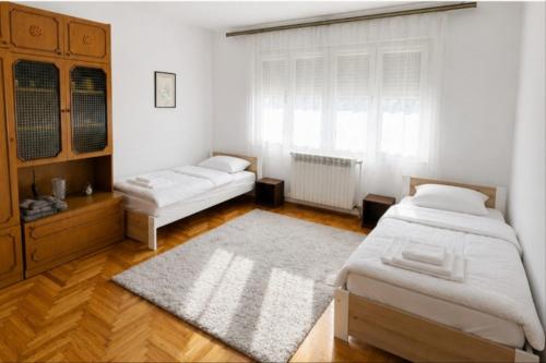 a bedroom with two beds and a window at L&M Apartman in Virje