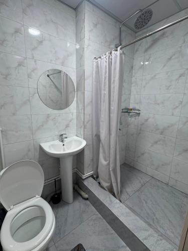 a bathroom with a toilet and a sink and a shower at Inju in Temirtaū