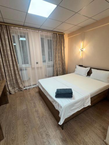 a bedroom with a bed with a suitcase on it at Inju in Temirtaū