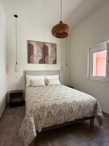 a bedroom with a bed and two pendant lights at AL do Barão - Casa de Charme com Piscina Privada in Vila Real de Santo António