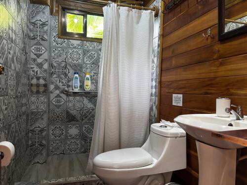 a bathroom with a toilet and a sink at Bambura Hermosa villas in Uvita