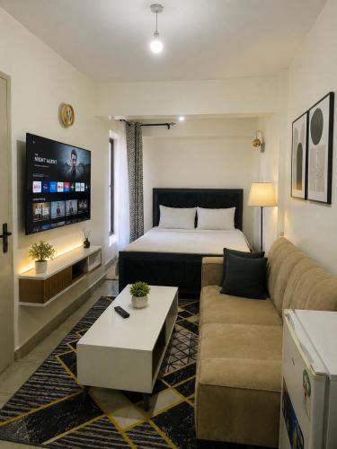 a hotel room with a bed and a couch at Residence Next Door Sunset in Kiambu