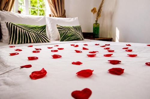 a bunch of red roses on a bed at Piton Views & Sunset Balcony, Minutes to Beaches in Soufrière