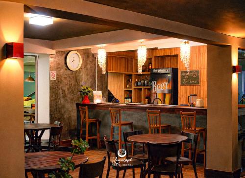 a bar with wooden tables and chairs in a restaurant at Kaakupe Praia Hotel in Guaratuba