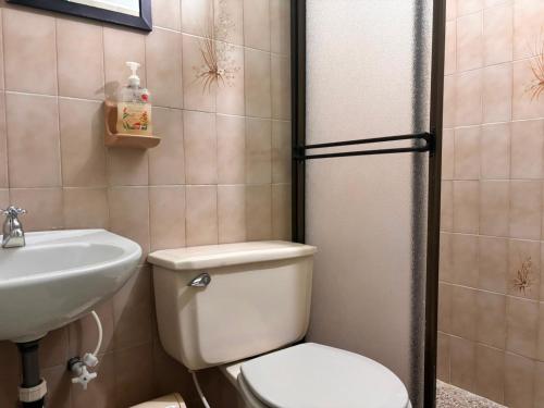 a bathroom with a toilet and a sink at Hotel Casa Verde Guatapé in Guatapé