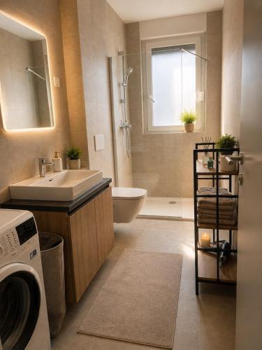 a bathroom with a sink and a washing machine at Apartman PEPI LUXURY in Novi Zagreb