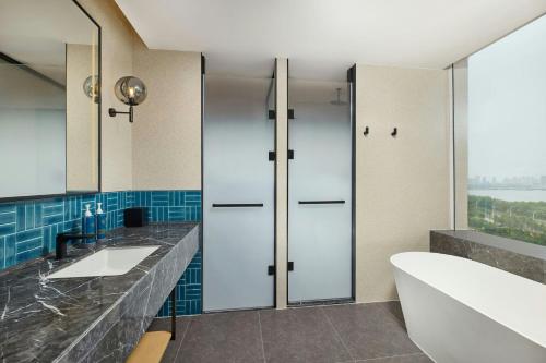 a bathroom with two sinks and a large mirror at Four Points by Sheraton Linyi Hedong in Linyi