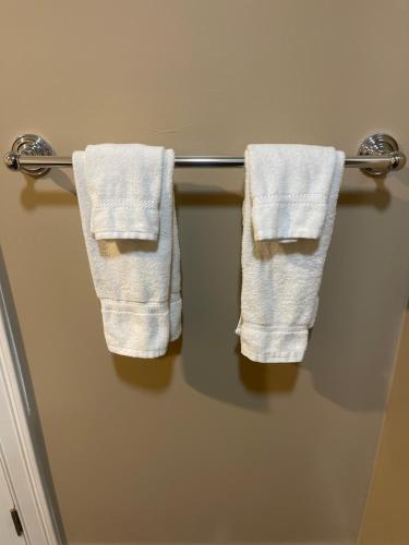 two white towels hanging on a towel rack in a bathroom at Monterey Fairgrounds Inn in Monterey