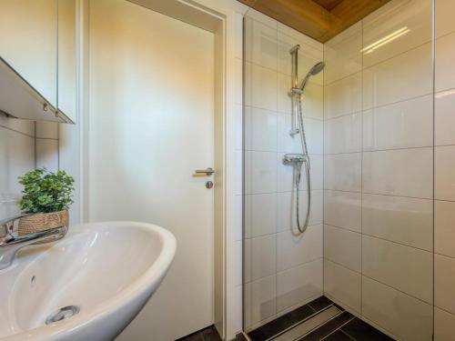a white bathroom with a shower and a sink at Kipaji 2 in Kötschach