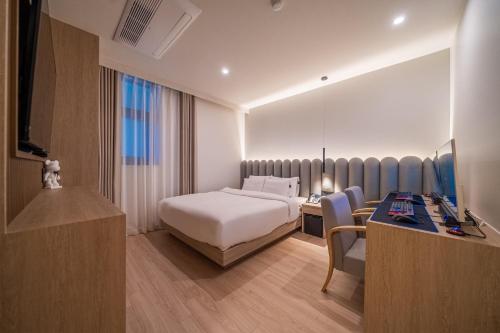 a hotel room with a bed and a desk at Gyeongju Poverta Hotel in Gyeongju