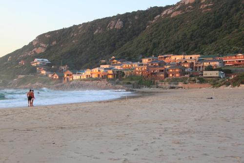a couple walking on a beach with houses at Net Hier in Eersterivierstrand