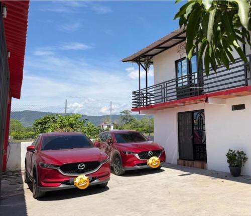 two red cars parked outside of a house at Diamante 38 in La Dorada