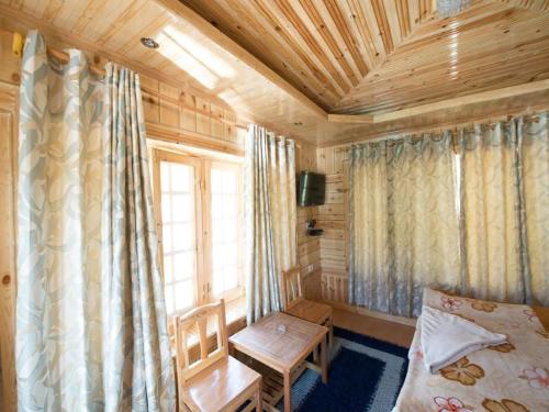 una camera con letto, finestra e tavolo di Nezer View Guest House a Leh