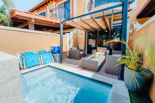 a swimming pool with chairs and a house at Gold coast beautiful house with private pool in Palm-Eagle Beach